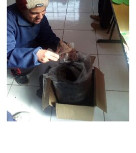 homem preparando vaso de garrafa pet para plantio no projeto APAE